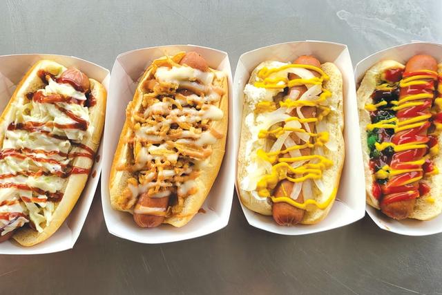 Four loaded hot dog builds lined up during a menu brainstorming session